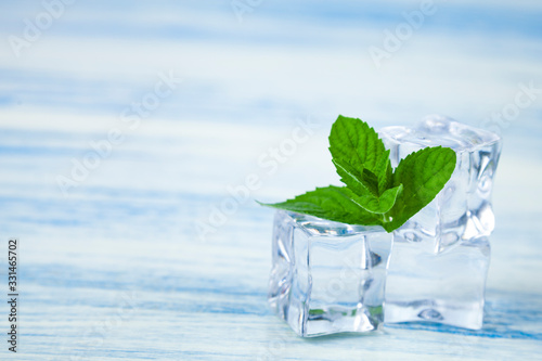 Ice and mint on a wooden table.