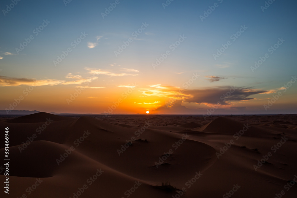 Sun setting over horizon in desert