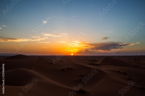 Sun setting over horizon in desert © BullRun