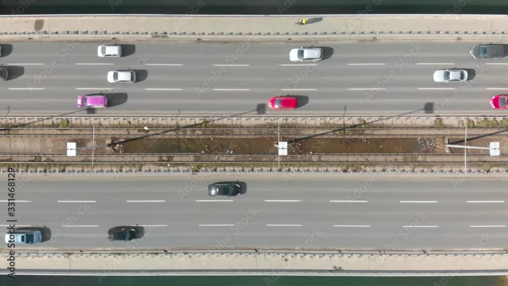 Aerial Drone Flight top down View of high way busy city traffic jam and a cyclist on bicycle lane. Car pooling natural power concept Aerial Drone Flight top down View of high way busy city traffic jam and a cyclist on bicycle lane. Car pooling natural power concept