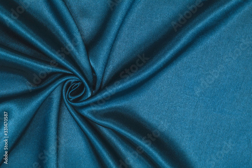 Smooth elegant blue silk or satin luxury cloth texture can be used as abstract background. Crumpled fabric Twisted at the side.