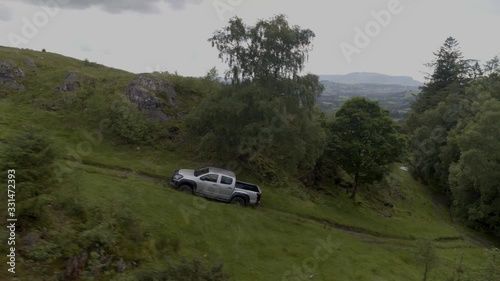 4K Aerial 4x4 Jeep driving uphill in countryside with reveal