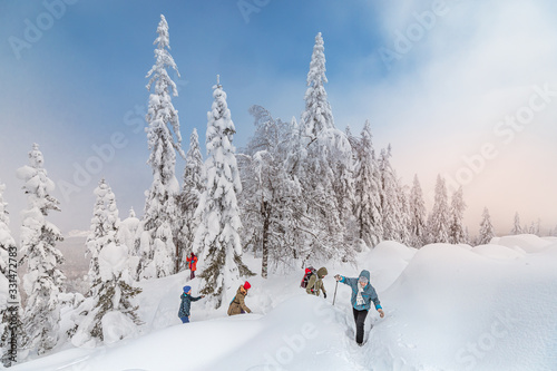 group of friends actively spend the weekend in a snow-covered winter forest. The concept of hardening and adventure