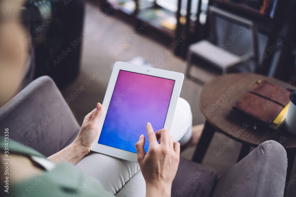 Faceless female using digital tablet indoors Faceless female using digital tablet indoors