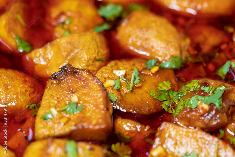 Indian Punjabi Dum Aloo - Indian vegetarian dish using potatoes, slow cooked in tomato onion, red chilli spiced gravy. Flat lay closeup shot. Concept for Indian cuisine, bengali regional food. Indian Punjabi Dum Aloo - Indian vegetarian dish using potatoes, slow cooked in tomato onion, red chilli spiced gravy. Flat lay closeup shot. Concept for Indian cuisine, bengali regional food.
