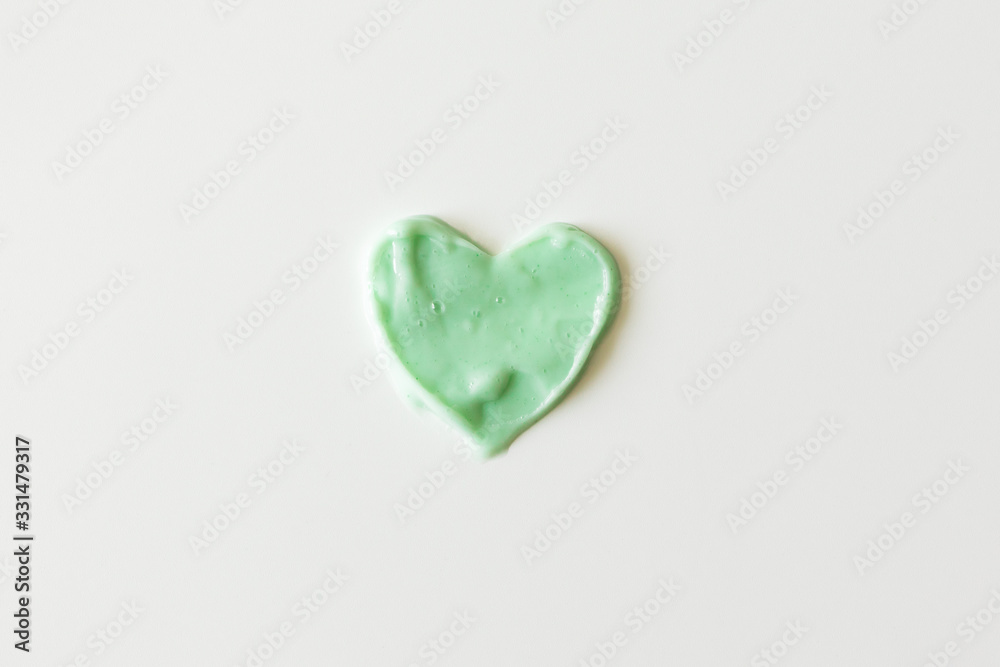Heart from shampoo, cleanser or shower gel on white background. Concept hygiene and healthcare, top view