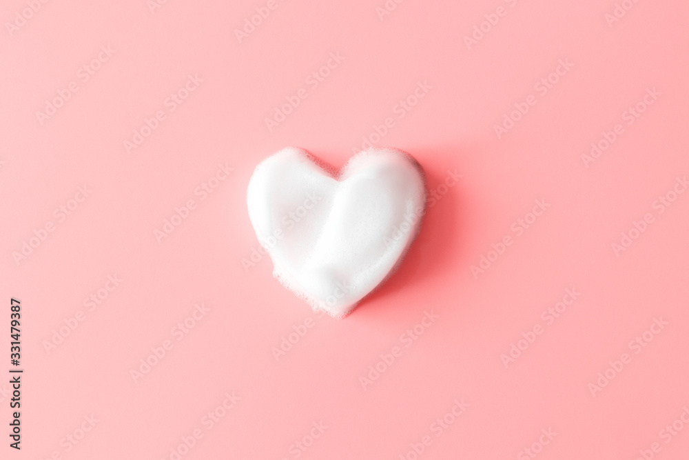 Heart from soap foam on pink background. White cleanser texture. Concept hygiene and healthcare - obrazy, fototapety, plakaty 