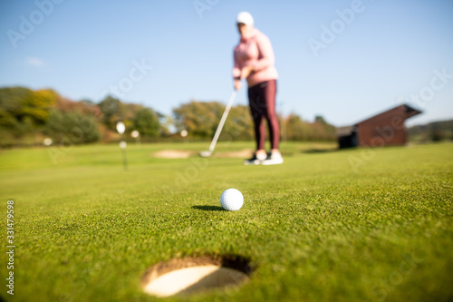 Female begginer golf player playing golf on the training ground, sport concept