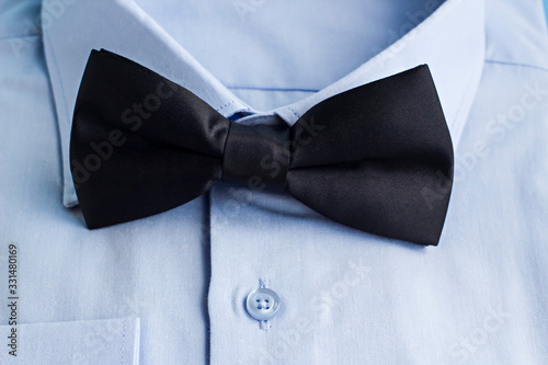 Stylish Black Color Bow Tie On Light Blue Male Shirt.Conceptual image of Father Day or any special day.