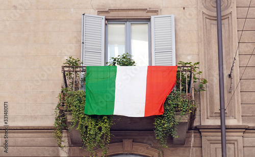 Europe, Italy , Milan - Flag of Italy hanging on the balcony of a house during n-cov19 Coronavirus epidemic emergency