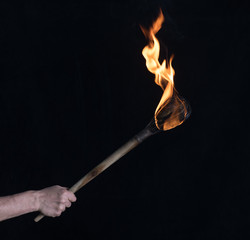 wooden burning torch on a black background
