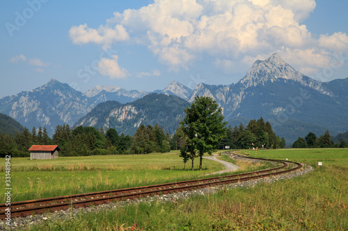 Obraz na plátně old curved railroad tracks with level crossing and haystack in an idyllic landsc
