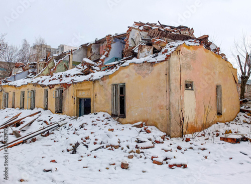 Destroyed old brick house in a snowfall
