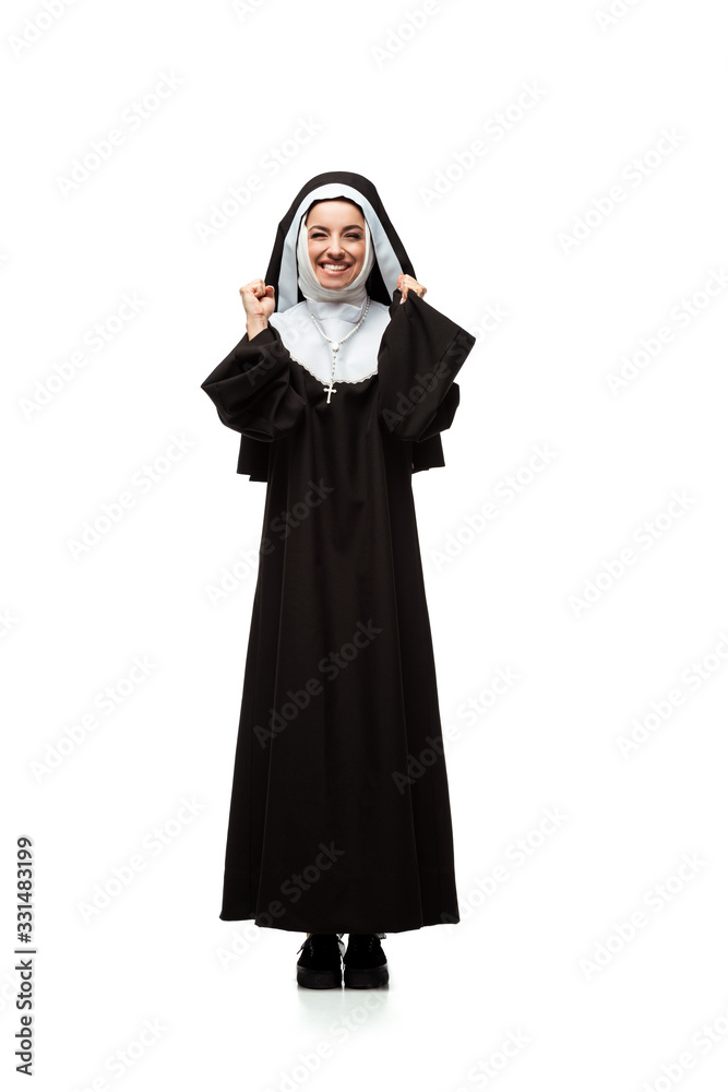 Naklejka premium beautiful young excited nun standing isolated on white