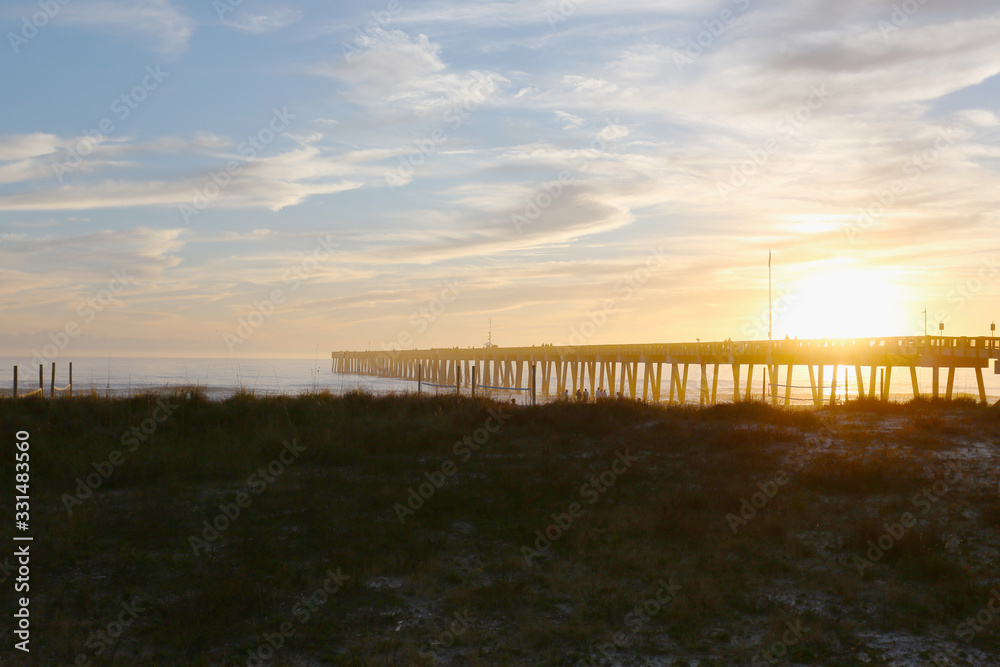 Panama city beach florida pier at sun down with beach silhouette and multi colored sky Panama city beach florida pier at sun down with beach silhouette and multi colored sky