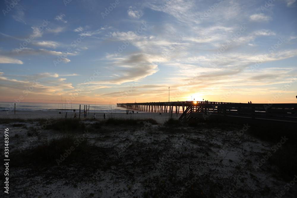 Panama city beach florida pier at sun down with beach silhouette and multi colored sky