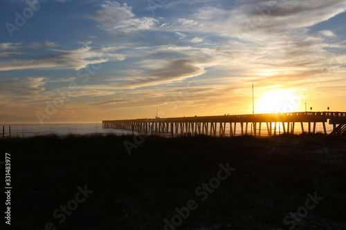 Panama city beach florida pier at sun down with beach silhouette and multi colored sky