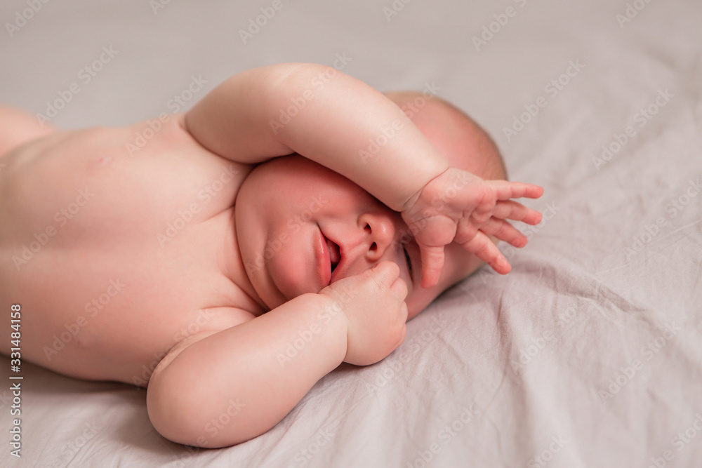 Happy 3 months old baby smiling, lying on white bed Happy 3 months old baby smiling, lying on white bed