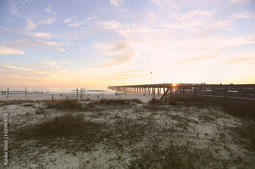 sundown at panama city beach pier with silhouette beach and pier and sunset clouds and sky