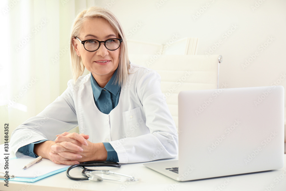 Portrait of mature female doctor in white coat at workplace Portrait of mature female doctor in white coat at workplace