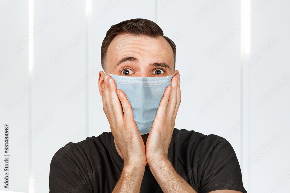 Unhappy, sad young man wearing a protective face mask prevent virus infection or pollution Unhappy, sad young man wearing a protective face mask prevent virus infection or pollution