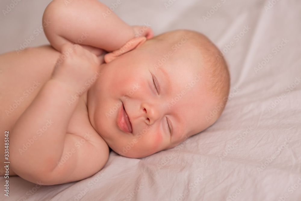 Happy 3 months old baby smiling, lying on white bed Happy 3 months old baby smiling, lying on white bed