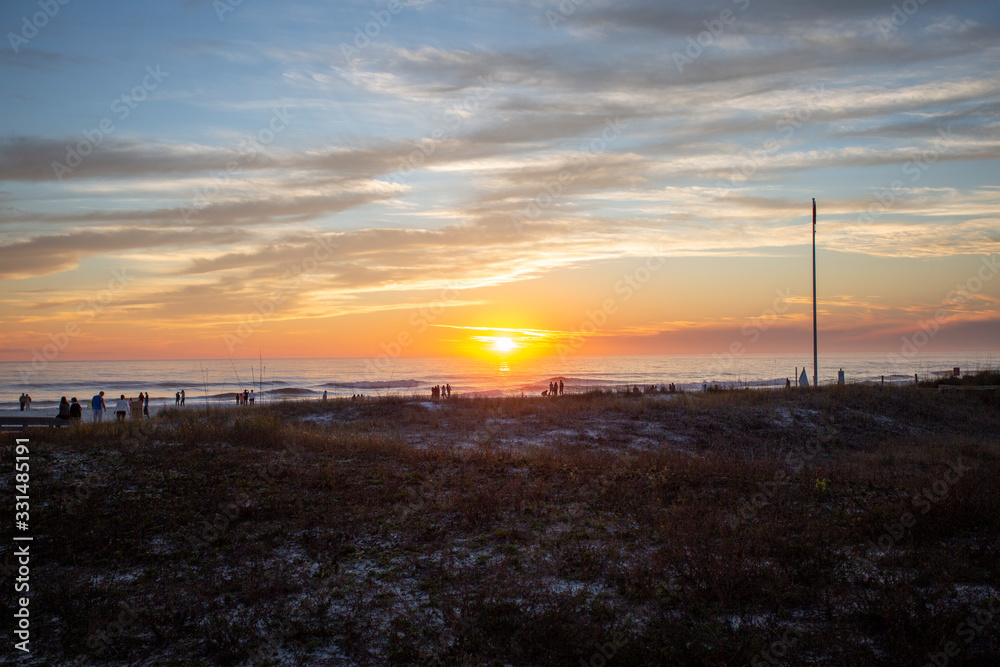 beautiful sunset sky sun going down over panama city beach with silhouettes of people beautiful sunset sky sun going down over panama city beach with silhouettes of people