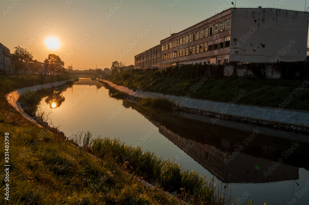 Naklejka premium A view of the Bega river early in the morning. Sunrise in the city. The leather and glove factory.