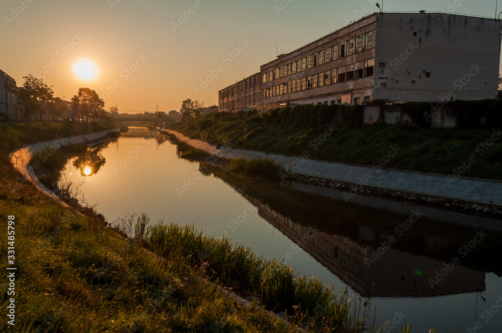 A view of the Bega river early in the morning. Sunrise in the city. The leather and glove factory.