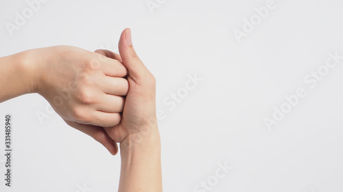 Male model is interlock fingers and rub mid-joints on white background.