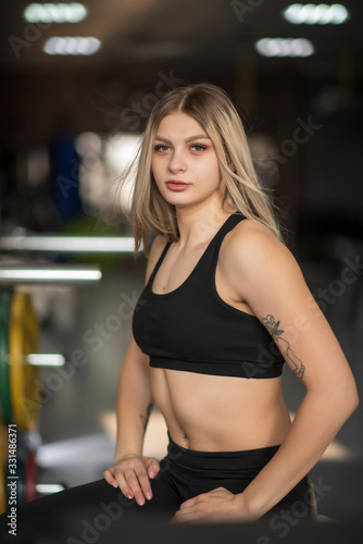 Portrait of a blonde girl with developing hair in a fitness gym.