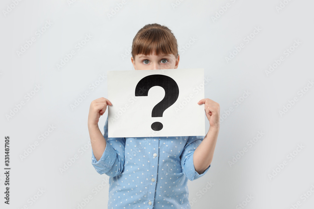 Girl holding sheet of paper with question mark on white background Girl holding sheet of paper with question mark on white background