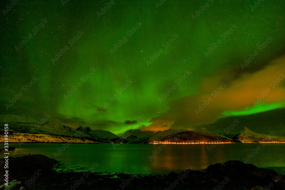 winter landscape with aurora, sea with sky reflection and snowy mountains. Aurora borealis. Lofoten islands, Norway.