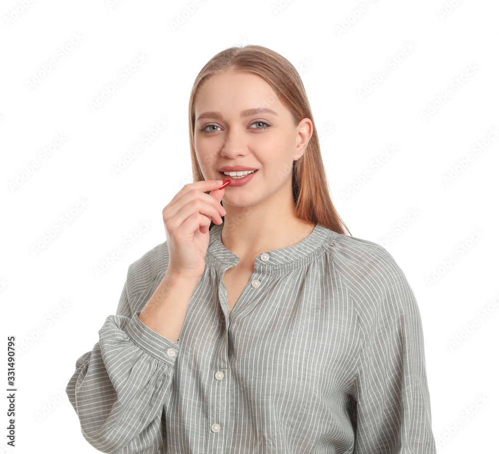 Young woman taking vitamin capsule on white background Young woman taking vitamin capsule on white background