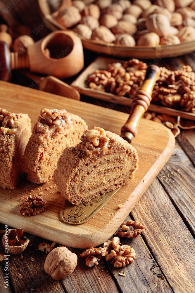 Walnut cake, nuts and wooden kitchen utensils on a wooden table. Walnut cake, nuts and wooden kitchen utensils on a wooden table.