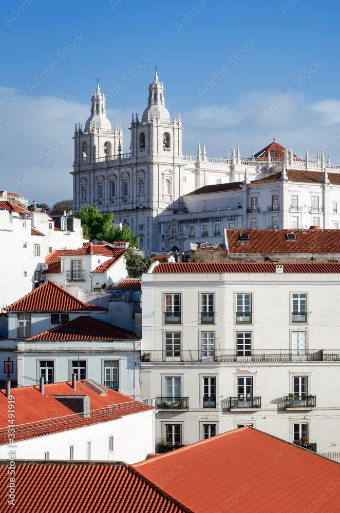 Facade and bell towers of che church of Sao Vincente de Fora in Lisbon, Portugal, with a view over the houses of the old Alfama district