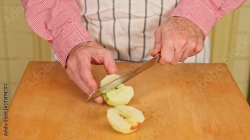 Man slices an apple on a butcher block. photo