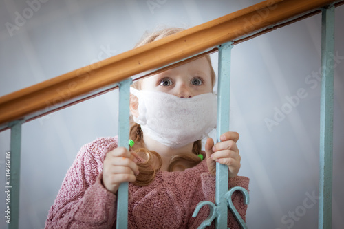 Sad child in a medical mask on his face.