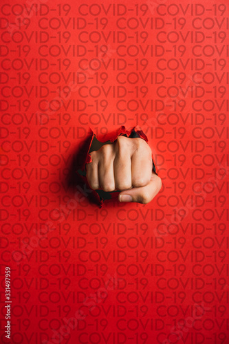 Wallpaper Mural Human hand tearing red paper with the word coronavirus, concept in the fight aga