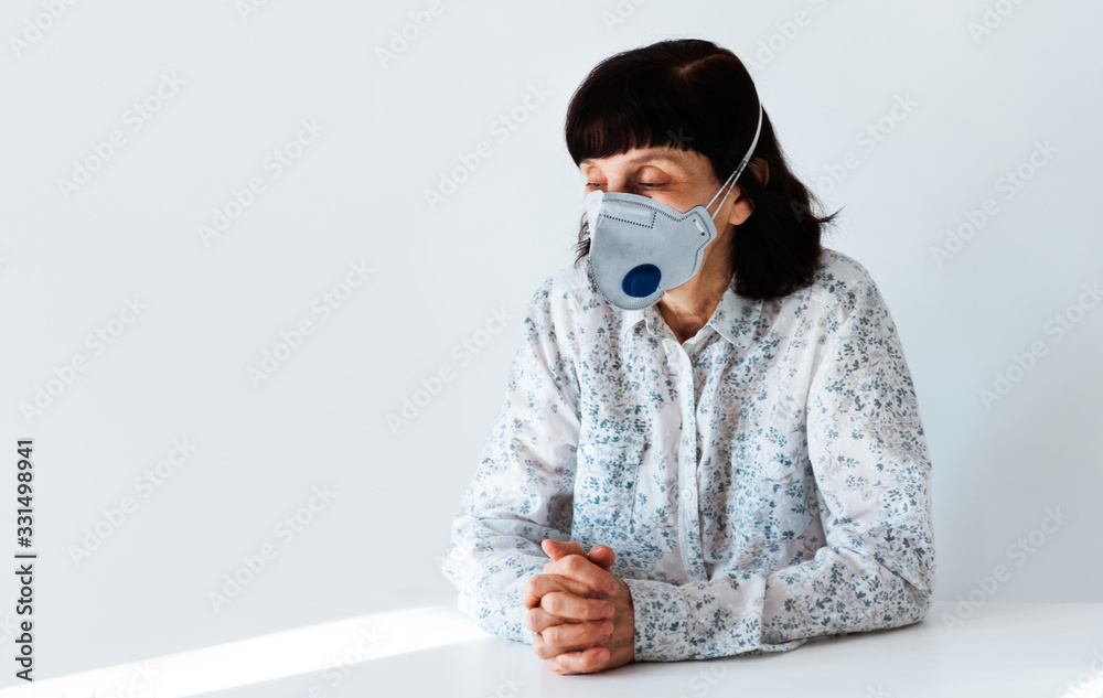 Coronavirus quarantine Covid-19 concept. Old sick woman wearing respirator mask for protect praying with folded hands. Wuhan, China epidemic virus symptoms background. Coronavirus quarantine Covid-19 concept. Old sick woman wearing respirator mask for protect praying with folded hands. Wuhan, China epidemic virus symptoms background.