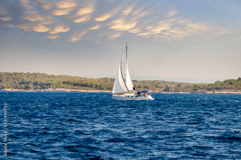 Obraz premium sailboat at sea under a magnificent sunset