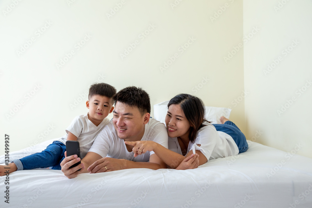 Happy young asian family take a self portrait with smartphone, Father, Mother and son little boy selfie on mobile phone Happy young asian family take a self portrait with smartphone, Father, Mother and son little boy selfie on mobile phone