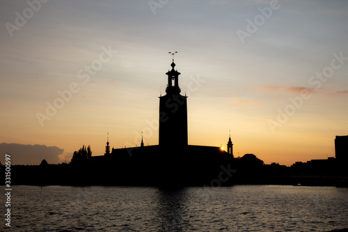 The iconic silhouette of Stockholm City Hall as the sun is setting behind it on a beautiful warm summer evening in Swedens capital