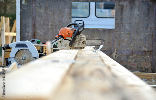 Konzept Krise im Handwerk: Arbeitsstopp oder Zwangspause auf einer verlassenen Baustelle mit einer MotorsÃ¤ge und einer KreissÃ¤ge - selektiver Fokus, viel Copyspace im Vordergrund photo