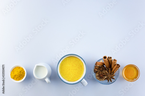 Golden milk  turmeric  honey  ginger root  cinnamon and other ingredients on grey background. Masala Haldi Doodh