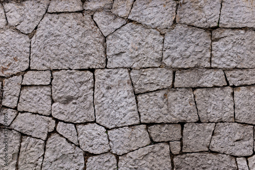 Texture of stone wall made of grey stones