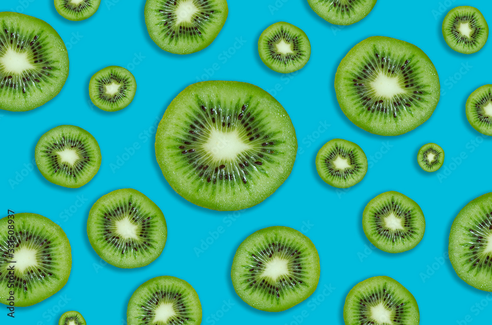 Fototapeta premium Cut kiwi on a blue background. Pattern