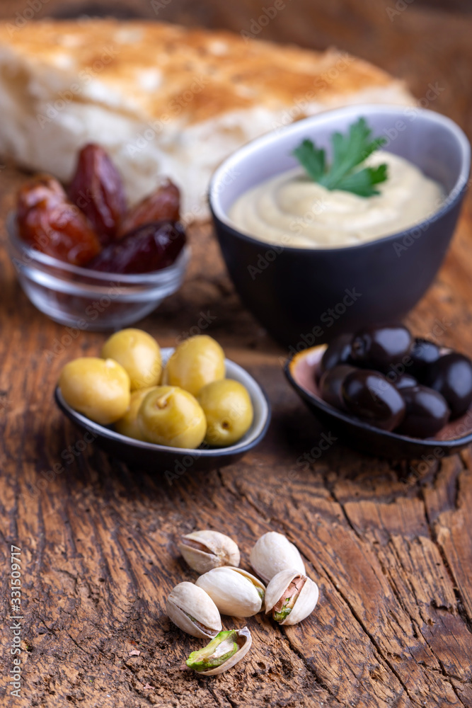 olives and hummus on dark wood