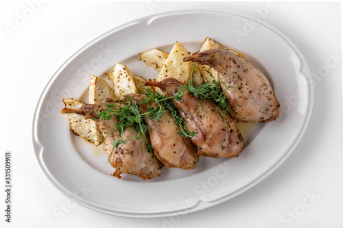 Baked tender juicy rabbit legs with celery. Banquet festive dishes. Gourmet restaurant menu. White background.