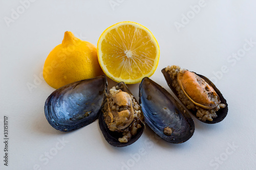 Traditional Turkish stuffed mussels on a white with fresh lemon and copy space,above view